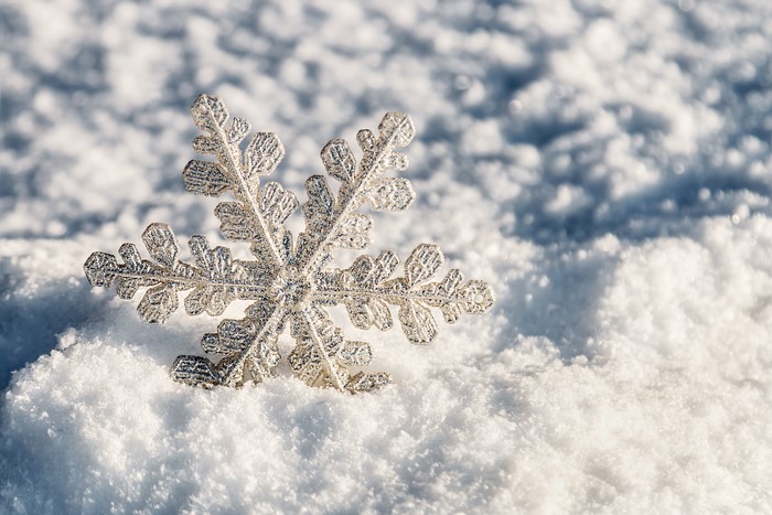 Close-up of a silver snowflake on snow