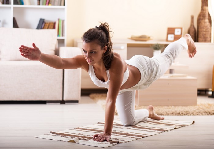 Woman performing yoga pose on a mat