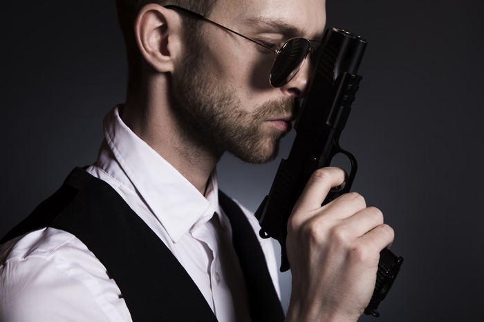 Man in Glasses Holding a Pistol