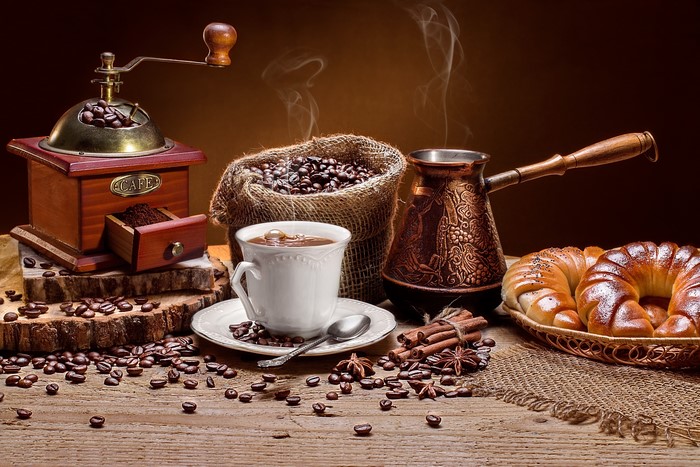 Coffee beans, grinder, cup, cezve, and pastries