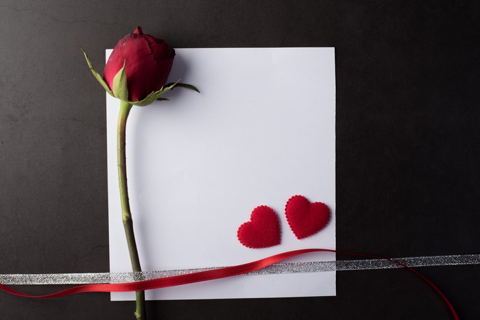 Red Rose on White Paper with Hearts and Ribbons