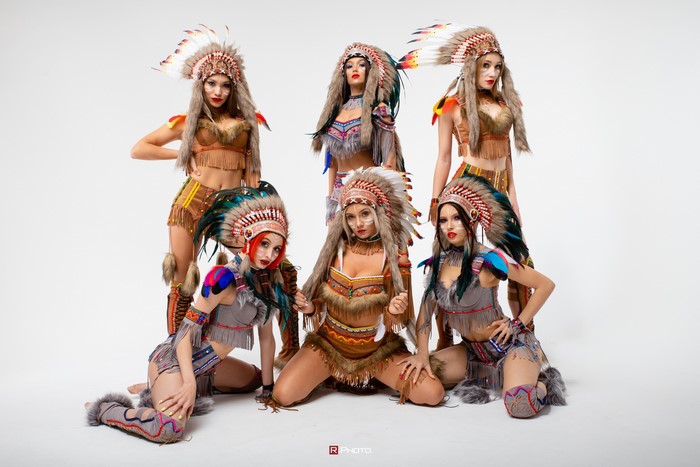 Six women in Native American costumes with headdresses