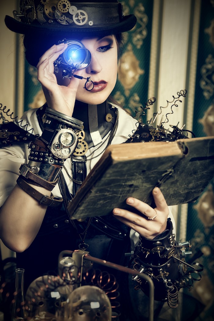 Steampunk woman with goggles reading a book