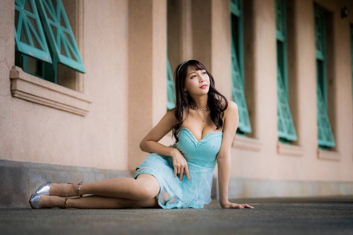 Asian woman in blue dress sitting on the ground