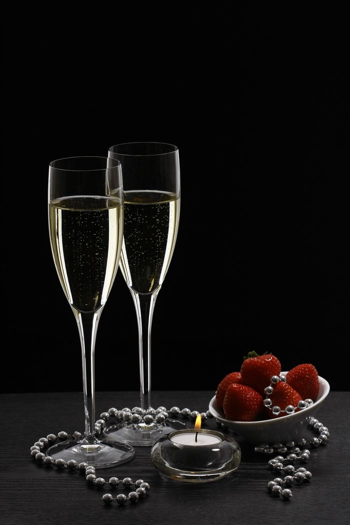 Champagne glasses with strawberries and candle