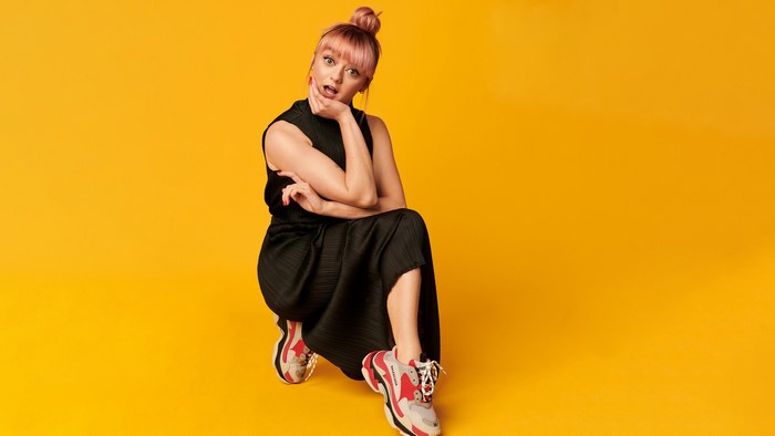 Maisie Williams in a black dress and athletic shoes