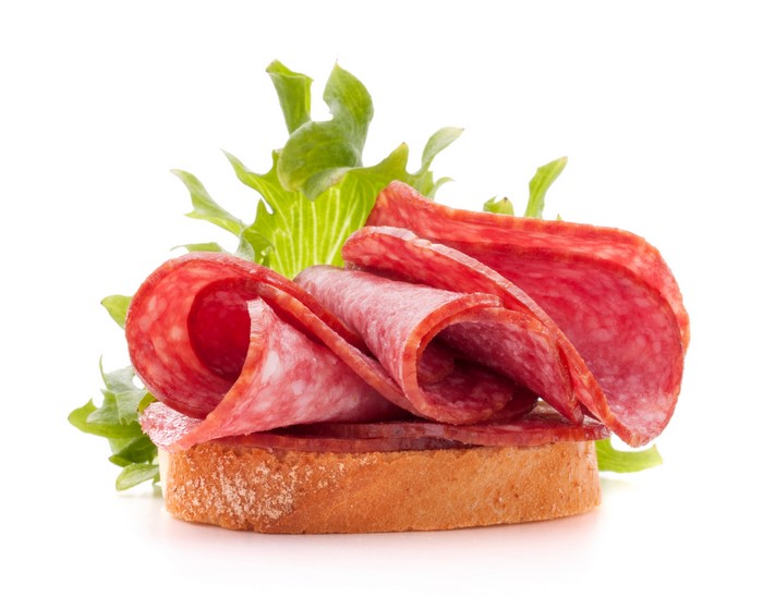 Salami sandwich with lettuce on white background