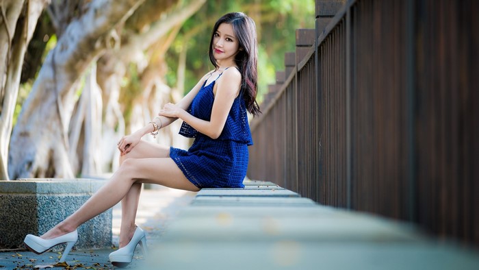 Brunette Asian girl sitting on a bench