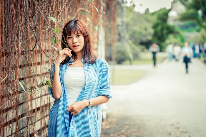 Asian woman with brown hair in a blue striped shirt