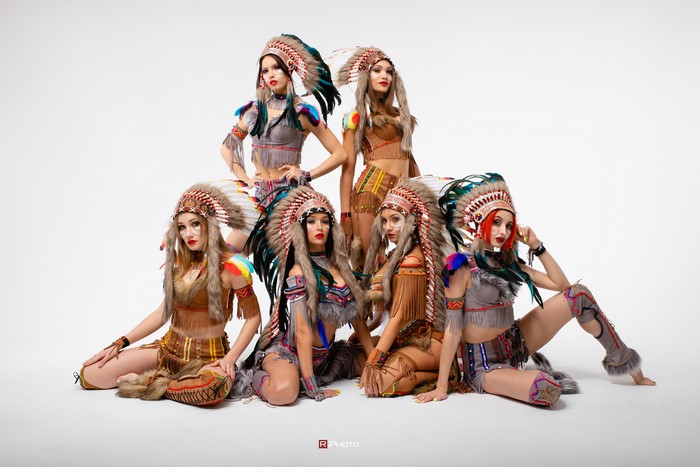 Six women in Native American headdresses and costumes