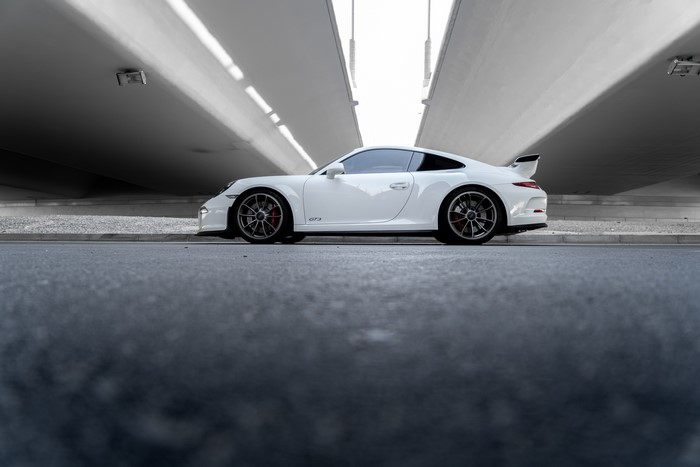 White Porsche 911 GT3 RS parked under a bridge