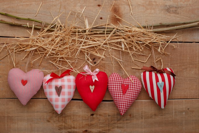Valentine's Day hearts on wood planks with straw and branches