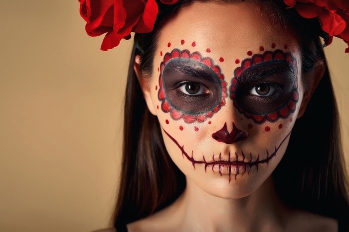 Woman with Day of the Dead makeup and red roses