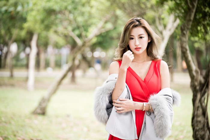 Asian woman in red dress with fur stole