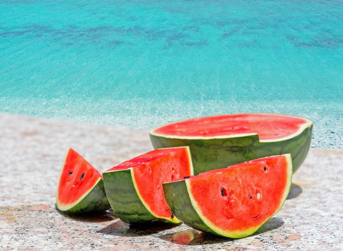 Watermelon slices on a beach by the ocean