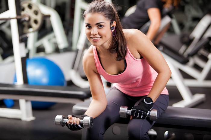 Woman lifting dumbbells in a gym