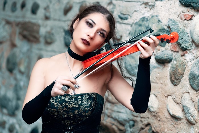 Woman playing a violin in gothic attire