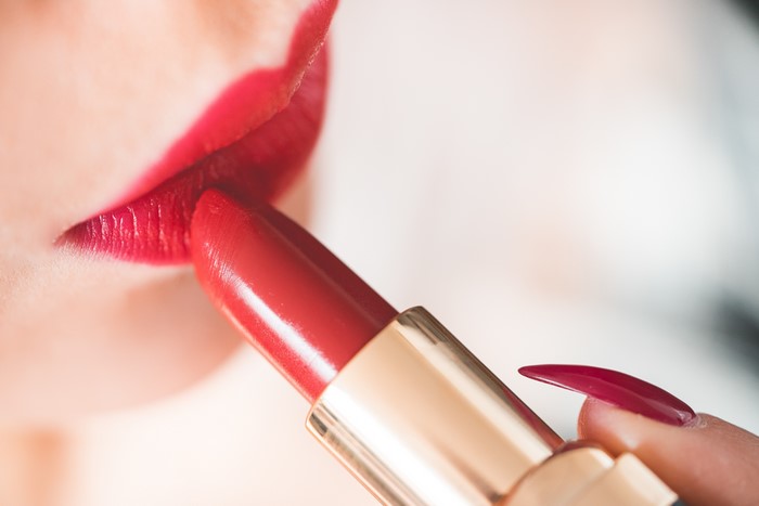 Closeup of red lipstick application on lips