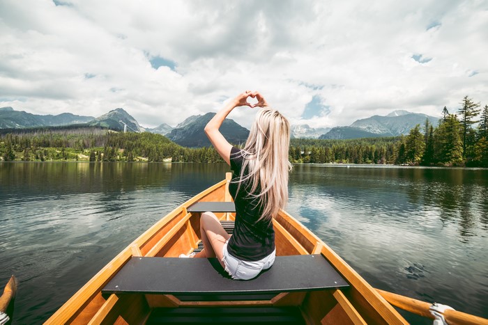 Woman in a boat making a heart shape with hands