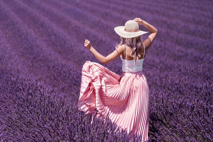 Woman in a hat and pink skirt in a lavender field