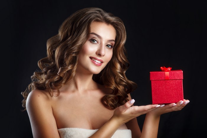 Woman with brown hair holding a red gift box