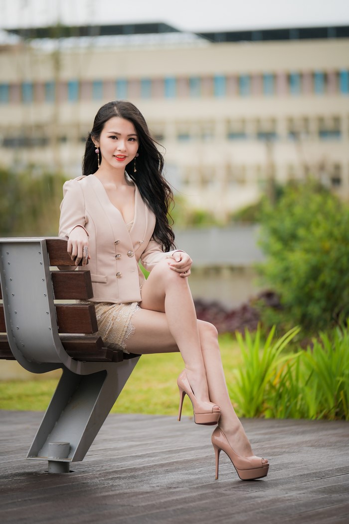 Asian Woman Sitting on Bench Wearing Stilettos