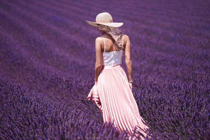 Woman in Hat Walking Through Lavender Field