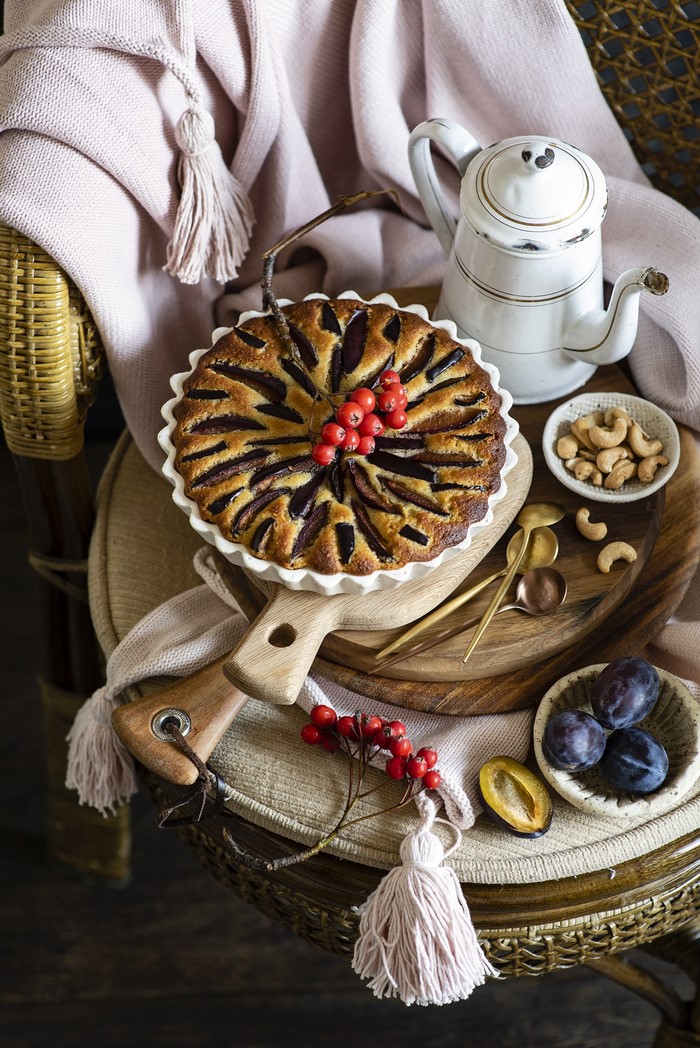 Plum pie with berries, nuts, and a teapot