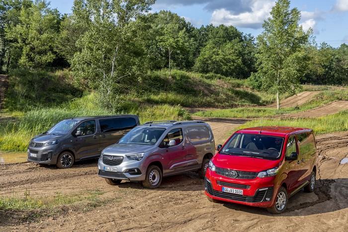 Three Opel Vans on a Dirt Track