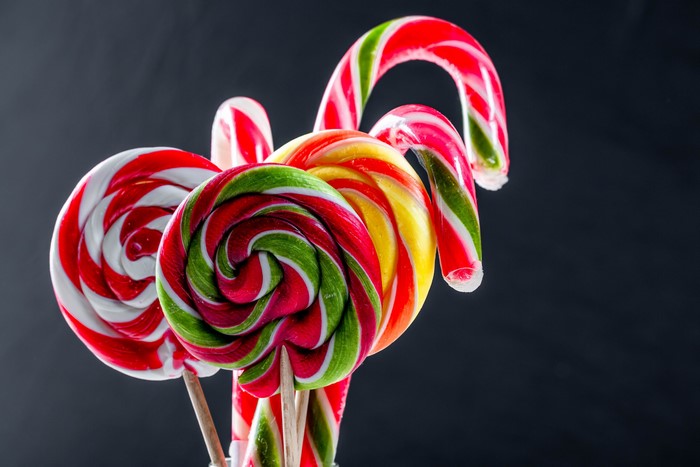 Colorful lollipops and candy canes on a dark background
