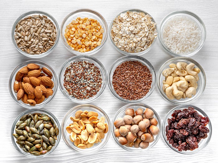 Bowls of assorted nuts, seeds, grains, and dried fruit