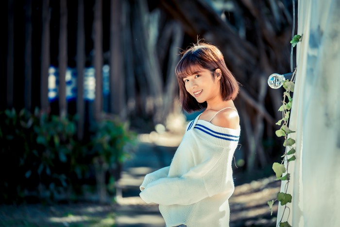 Asian woman with brown hair smiling in a sweater