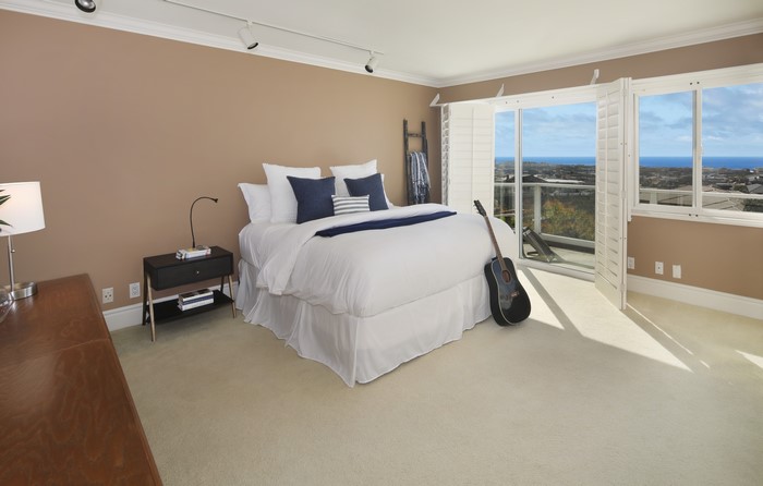 Bedroom with bed, guitar, and ocean view