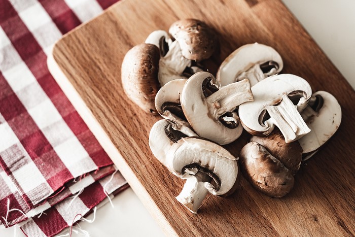 Mushrooms on a cutting board with a checkered cloth