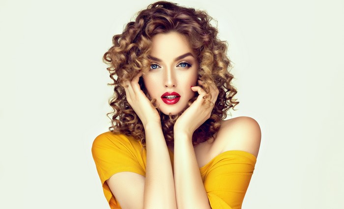 Beautiful woman with curly brown hair and red lips