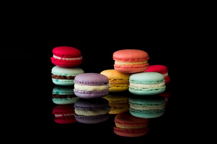 Multicolor macarons with reflection on black background