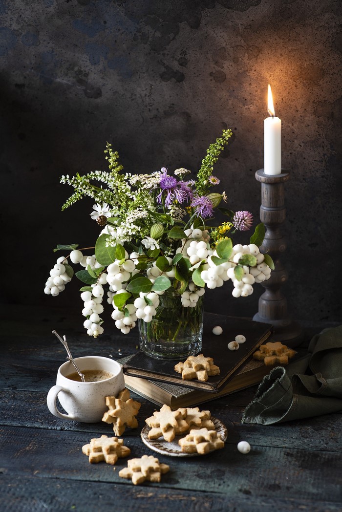 Still life with flowers, coffee, cookies, and candle