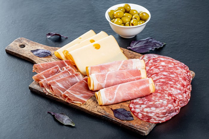 Charcuterie board with ham, salami, cheese, and olives