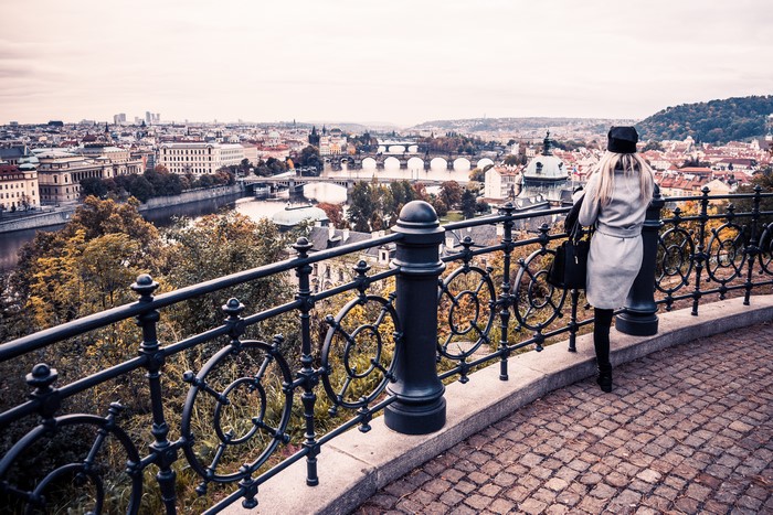 Woman overlooking Prague cityscape with bridges and river