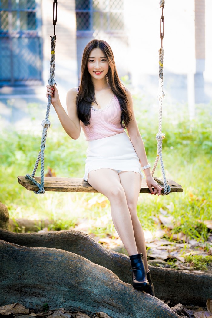 Asian Woman Sitting on Swing with Smile