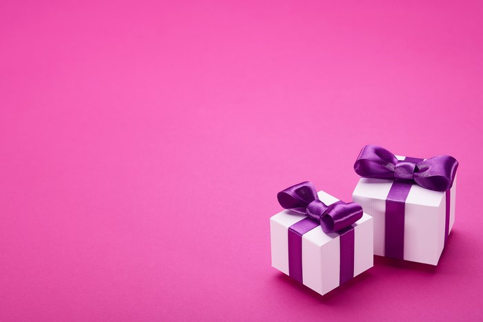 Two Gifts with Purple Bows on Pink Background