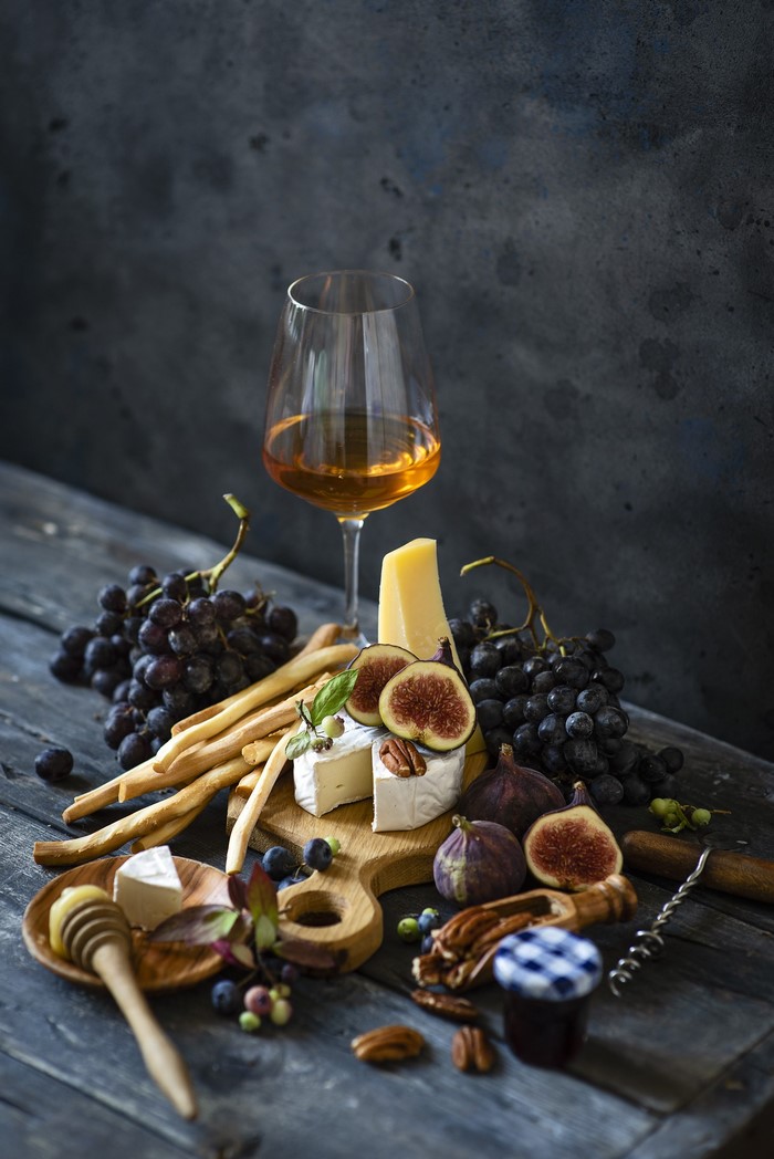 Wine, cheese, grapes, figs, and breadsticks still life