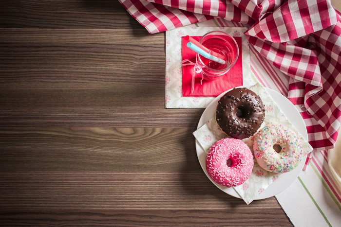 Three donuts and a drink on a wooden table