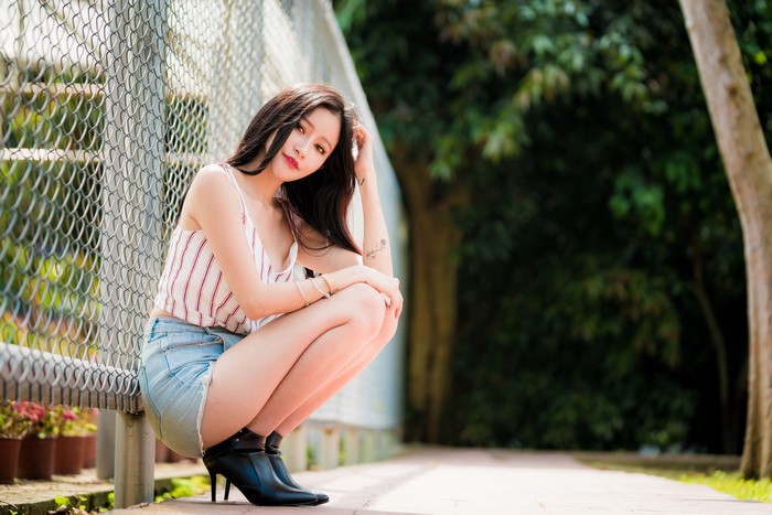 4K Asian Woman Sitting by Fence with Bokeh