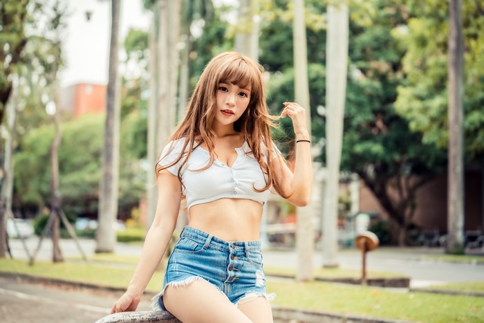 Asian woman in singlet and shorts posing outdoors