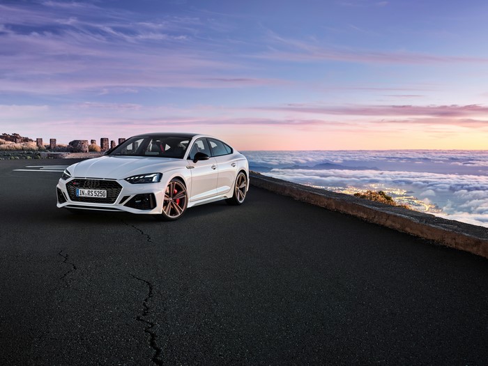 White Audi RS 5 Sportback on a mountain road at sunset