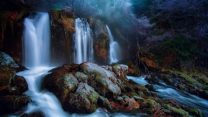 Frozen waterfall in a misty forest