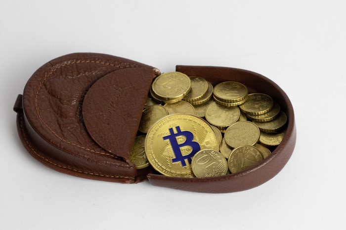 Bitcoin and coins in a brown leather wallet