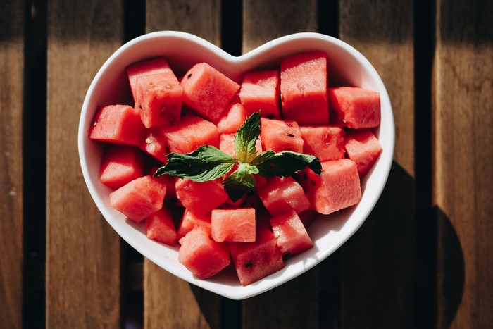 Watermelon cubes in a heart-shaped bowl with mint