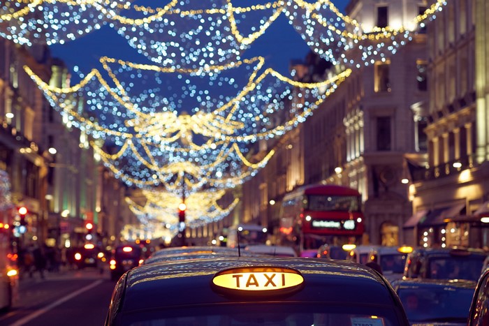 Taxi in London street with fairy lights at night